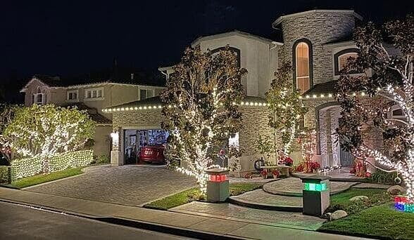 Bright White Christmas Lights on House and Trees with Decorations